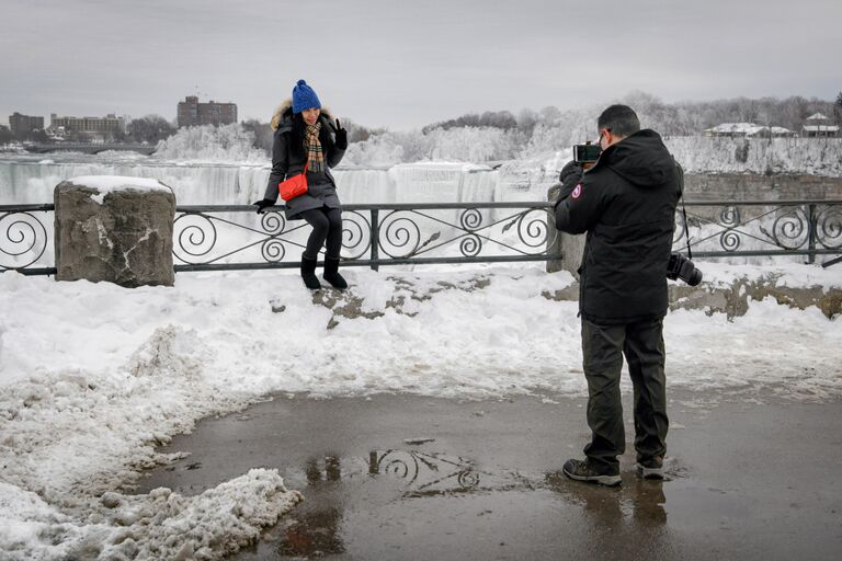 Туристы фотографируются возле Ниагарского водопада