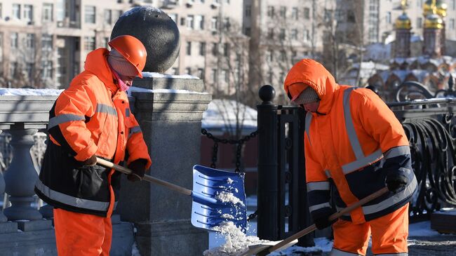 Сотрудники коммунальных служб убирают снег