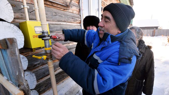 Техник газовой службы подключает газ в жилой дом