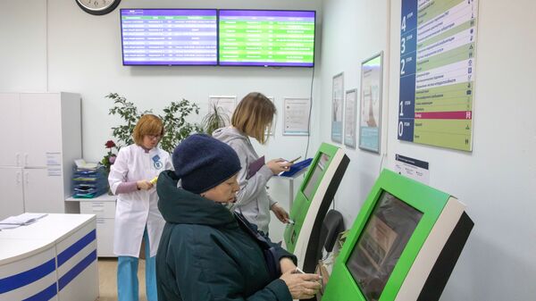  Пациенты записываются на прием к врачу через электронные терминалы в городской поликлинике № 68 в Москве