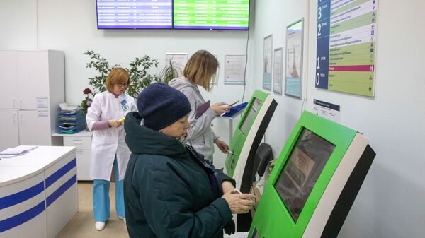  Пациенты записываются на прием к врачу через электронные терминалы в московской поликлинике