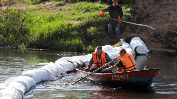 Сотрудники МЧС РФ выставляют боновые заграждения на одной из рек