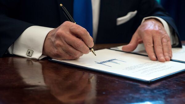 Президент США Дональд Трамп подписывает документ в Овальном кабинете Белого дома