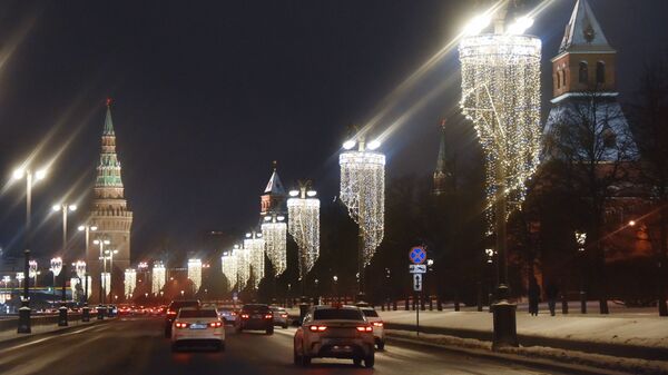 Новогодние гирлянды на фонарях на Кремлевской набережной в Москве