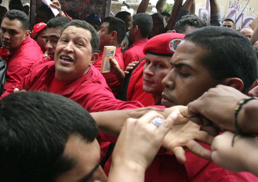 Президент Венесуэлы Уго Чавес приветствует сторонников во время визита в бедный район Каракаса
