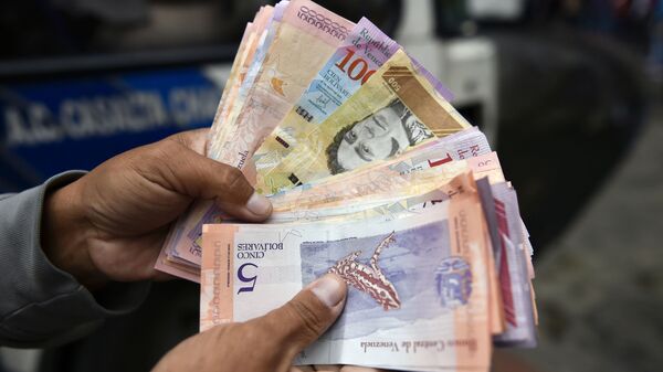 Мужчина пересчитывает деньги на улице в Каракасе