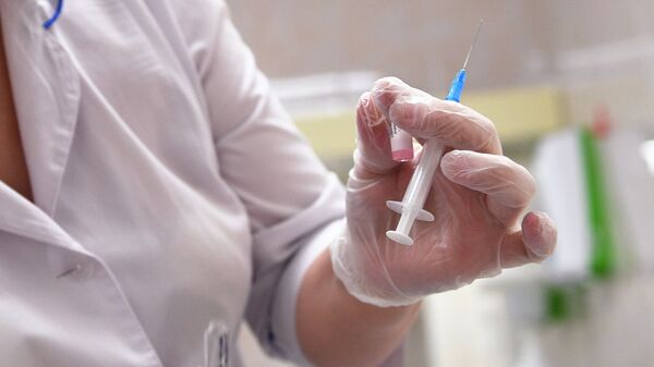 Медицинская сестра готовит шприц для прививки от кори в детской поликлинике 