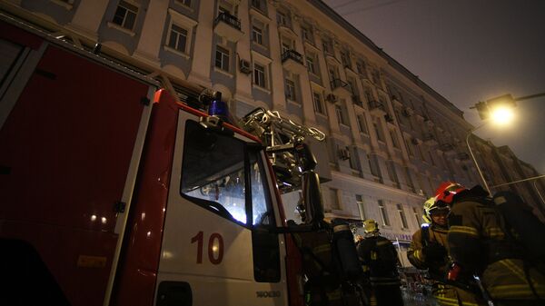 Сотрудники пожарной службы у здания на Никитском бульваре в центре Москвы, где произошел пожар.