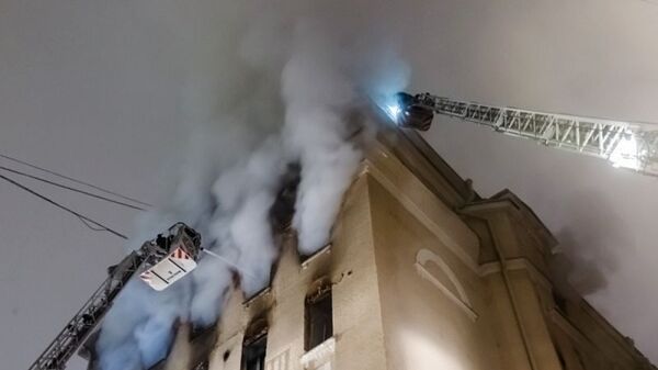 Сотрудники пожарной службы тушат пожар в здании на Никитском бульваре в центре Москвы