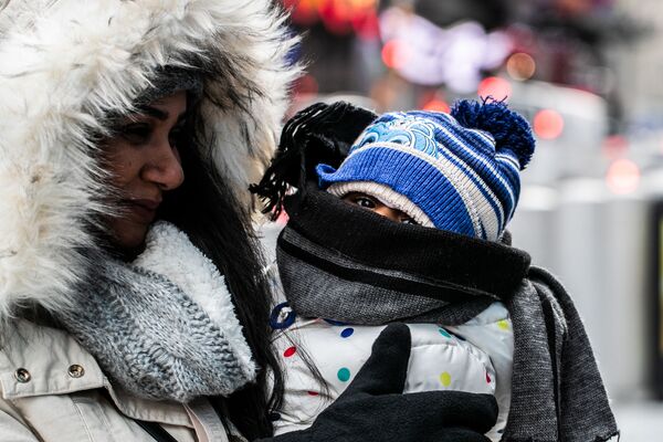 Женщина с ребенком в холодную погоду на Манхэттене в Нью-Йорке. Сильные холода обрушились на значительную часть территории США