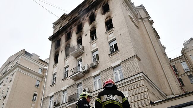 Сотрудники МЧС рядом с жилым домом на Никитском бульваре в Москве, где произошел пожар