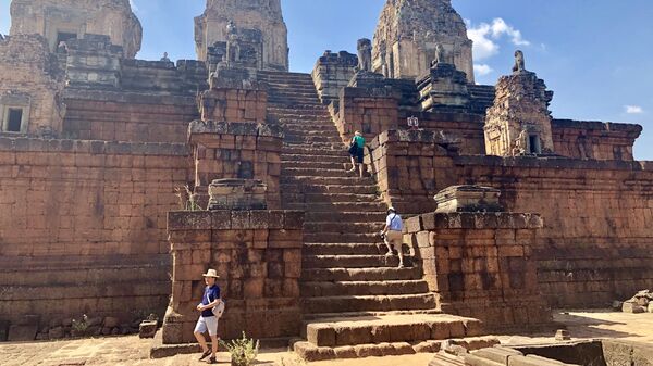 Туристы взбираются по колеснице храма, Анкор, Камбоджа