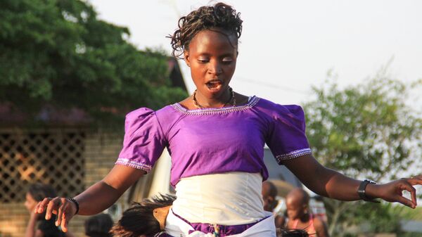 Африканская певица выступает на уличном мероприятии в Кампале, Уганда