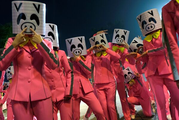 Участники парада в масках свиней во время Лунного Нового года в Гонконге