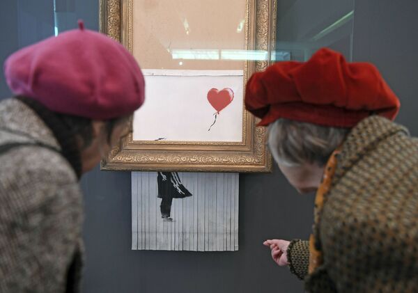 Посетители рассматривают самоуничтожившуюся картину Бэнкси Любовь в мусорной корзине в музее Фридера Бурды в Баден-Бадене