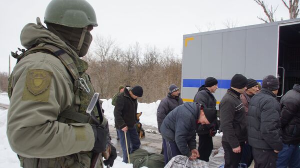 Заключенные и сотрудник полиции ЛНР во время передачи Киеву заключенных, пожелавших отбывать наказание на подконтрольной властям Украины территории