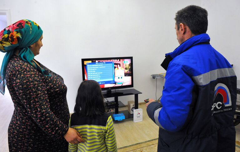 Инженер настраивает приставку цифрового телевидения в одном из жилых домов в Гудермесе Инженер настраивает приставку цифрового телевидения в одном из жилых домов в Гудермесе