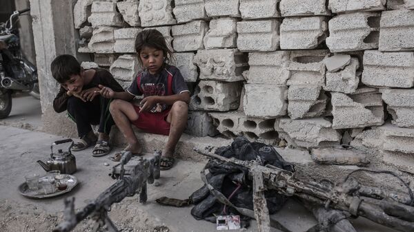 Дети смотрят на оружие, оставленное боевиками ИГ (запрещена в РФ) в Кобани, Сирия. 2015 год. 