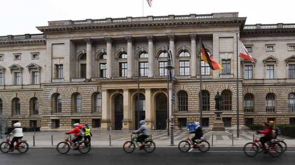 Велосипедисты едут мимо здания Палаты депутатов Берлина 