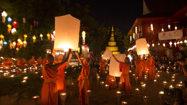 Буддийские монахи готовятся выпустить фонари в небо, после церемонии благословения на фестивале Лой Кратонг в храме в Чиангмай, Таиланд