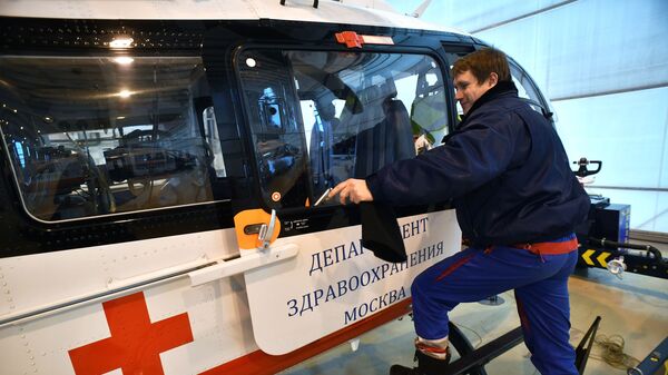 Сотрудник у вертолета BK-117C-2 в ангаре Московского авиационного центра