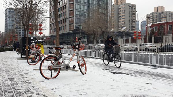 Женщина на велосипеде на одной из улиц Пекина