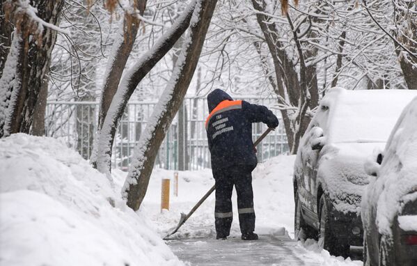 Сотрудник коммунальных служб убирает снег в Москве