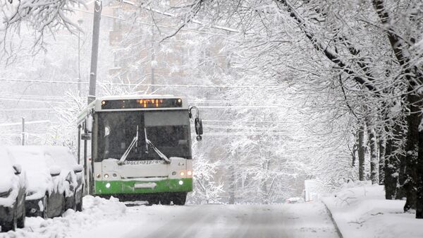 Автобус движется по заснеженной улице в Москве