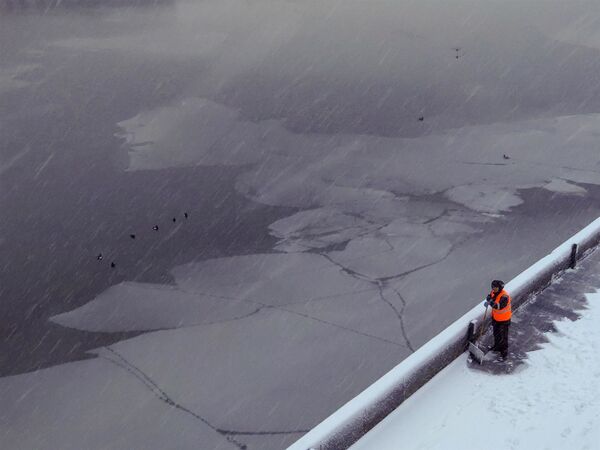 Сотрудник коммунальных служб убирает снег в Москве
