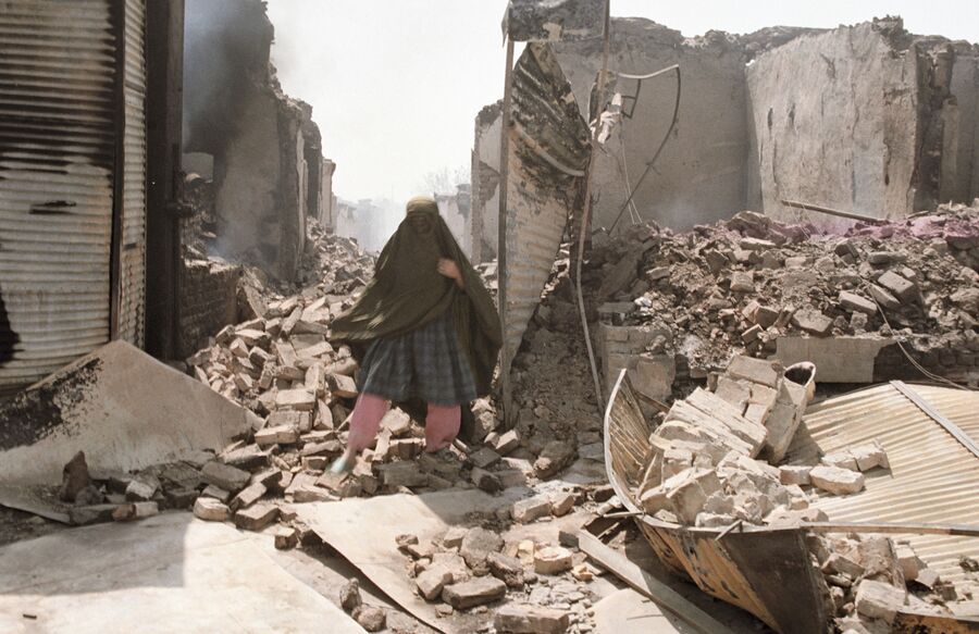Жительница Кундуза на руинах, оставленных отрядами исламской оппозиции во главе с Ахмад Шахом Масудом