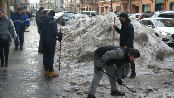 Бармены расчищают снег и наледь на улице Рубинштейна в Санкт-Петербурге