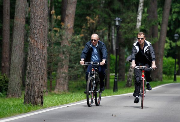 Президент РФ Дмитрий Медведев и председатель правительства РФ Владимир Путин катаются на велосипедах во время неформальной встречи в подмосковной резиденции Горки. 11 июня 2011 года