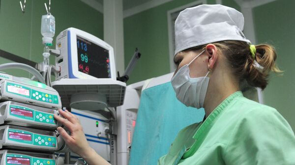 Медицинская сестра проводит коррекцию параметров инфузионной терапии на аппарате в отделении реанимации и интенсивной терапии новорожденных