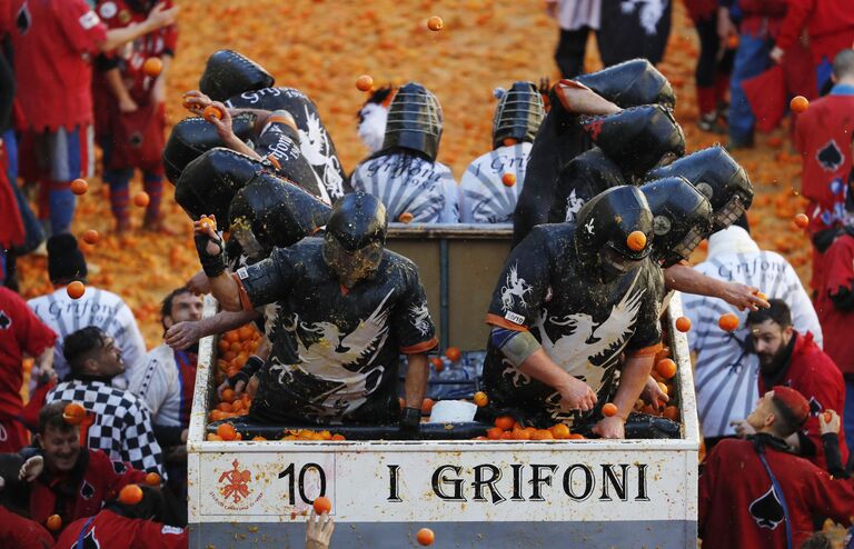 Участники Битвы апельсинов во время карнавала в Иврее, Италия Участники Битвы апельсинов во время карнавала в Иврее, Италия