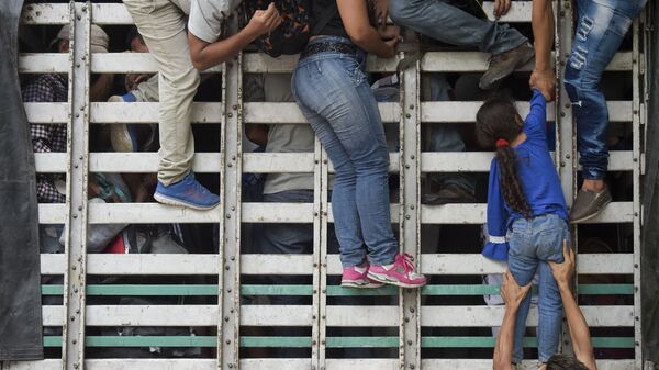 Мигранты из Венесуэлы забираются в грузовик по дороге в Колумбию. Архивное фото