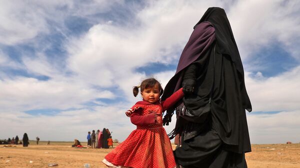 Женщина с ребенком бегут из лагеря беженцев в деревне Багуз, спасаясь от террористов в провинции Дейр-эз-Зор