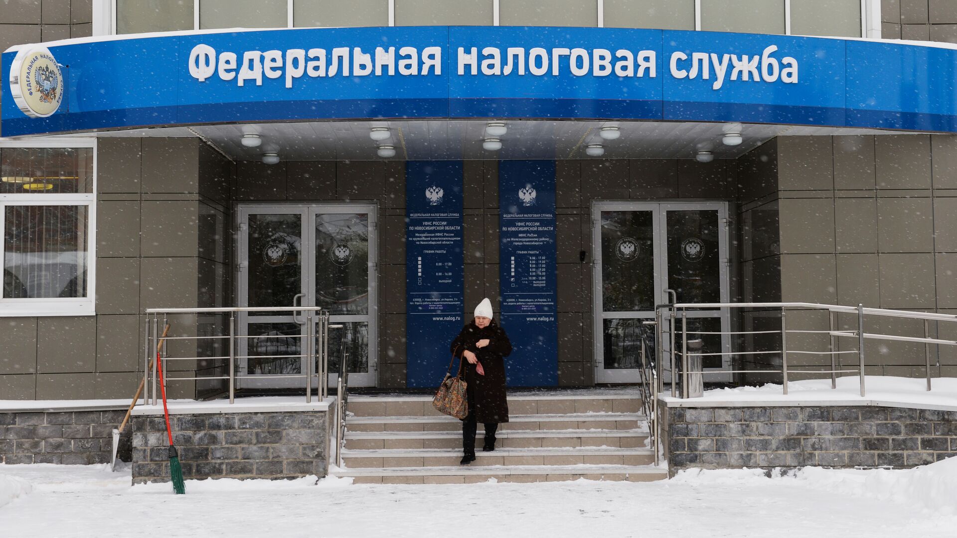 Женщина выходит из здания инспекции Федеральной налоговой службы России в Новосибирске - РИА Новости, 1920, 19.02.2022