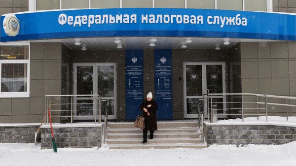 Женщина выходит из здания инспекции Федеральной налоговой службы России в Новосибирске