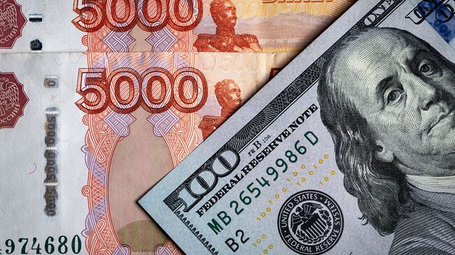Денежные купюры: российский рубли и доллары США. Архивное фото