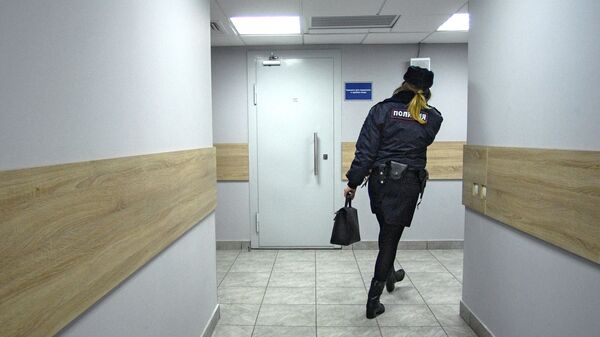 Сотрудник полиции идет по коридору дежурной части аэропорта Внуково