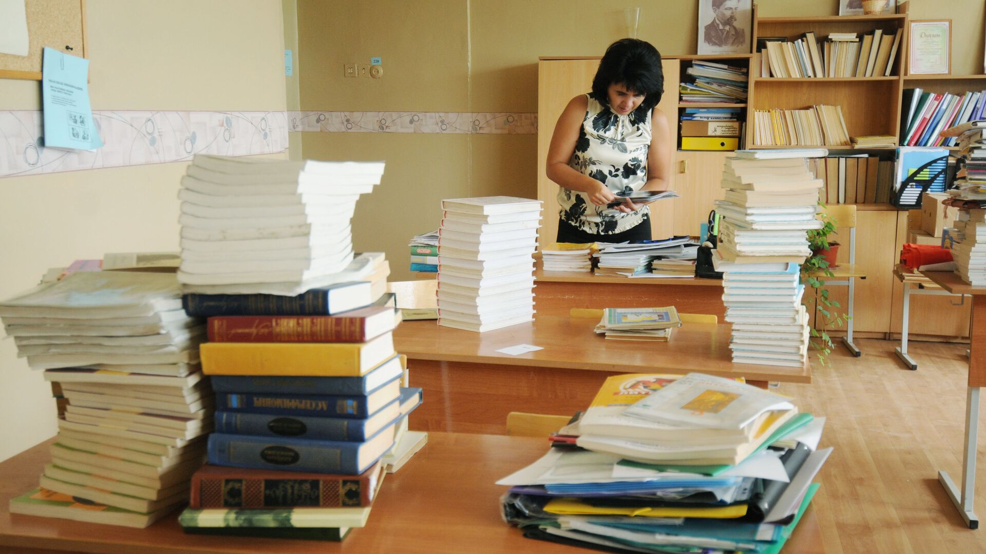 Учительница сортирует учебники в классе - РИА Новости, 1920, 14.03.2022