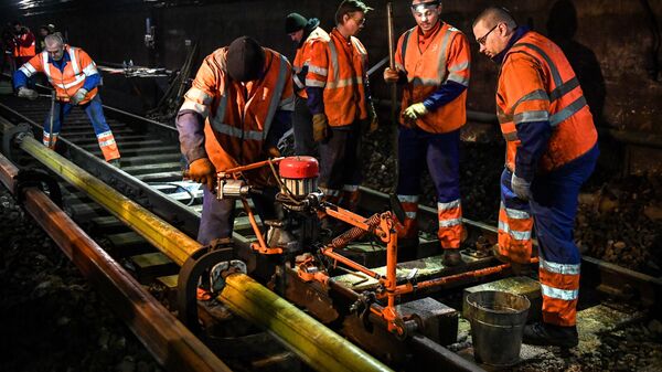 Рабочие во время замены шпал в тоннеле на станции Красносельская