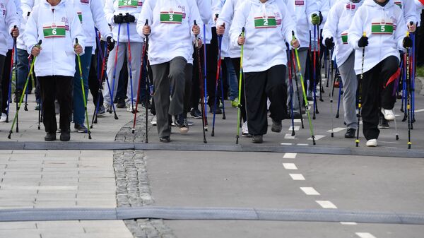 Участники массового марафона по скандинавской ходьбе среди пенсионеров в ландшафтном парке Митино
