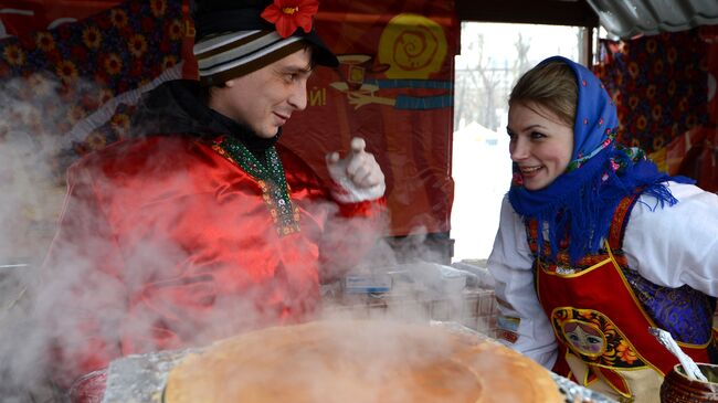 Выпекание блинов во время Масленичных гуляний