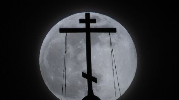 Православный крест в Москве на фоне луны