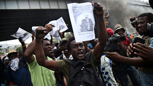 Участник акции протеста с портретом Владимира Путина в столице Гаити Порт-о-Пренсе. 15 февраля 2019
