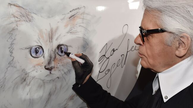 Модельер Карл Лагерфельд рядом с портретом своей кошки по кличке Шупетт
