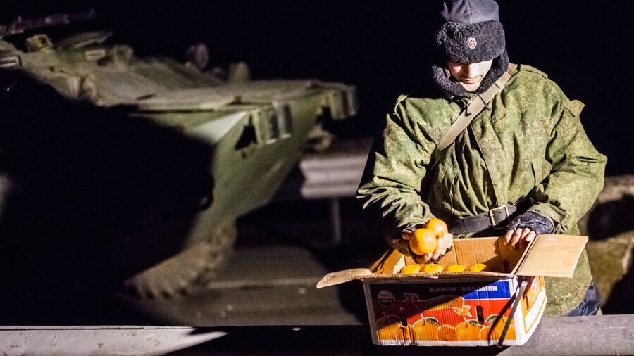 Военнослужащий с ящиком мандаринов на блокпосту на въезде в Крым в районе Армянска