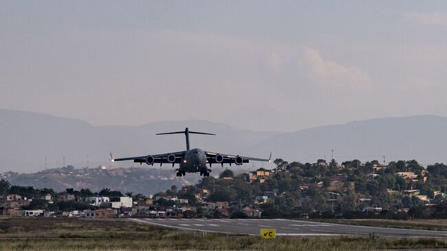 Американский военно-транспортный самолет C-17 Globemaster III  заходит на посадку в колумбийской Кукуте на границе с Венесуэлой