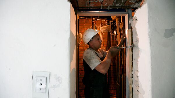 Специалист проводит замену лифтового оборудования в многоэтажном жилом доме